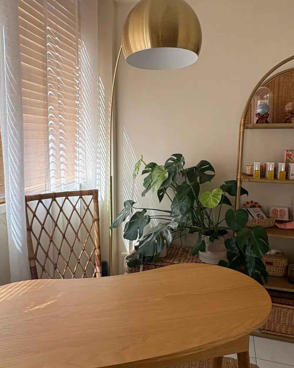 Le cabinet : une table en bois clair, une lampe dorée et des plantes
